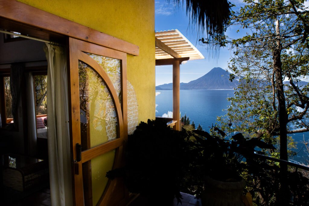 Villa Bambu view: Lake Atitlán vista from a yellow room with a wooden frame.