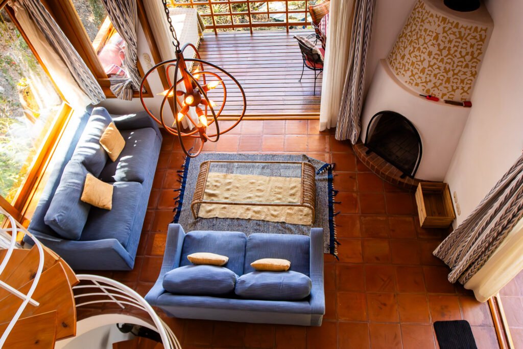 Villa Bambu living room with blue couches, terracotta tile floor, and a unique light fixture.