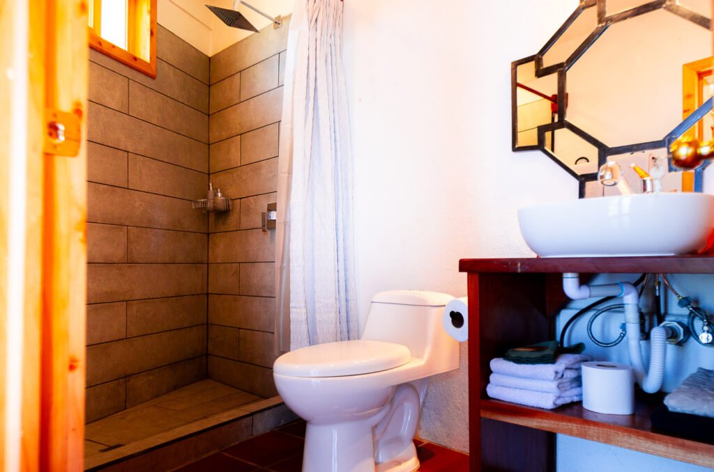 Villa Gio bathroom with walk-in shower, toilet, and modern sink.