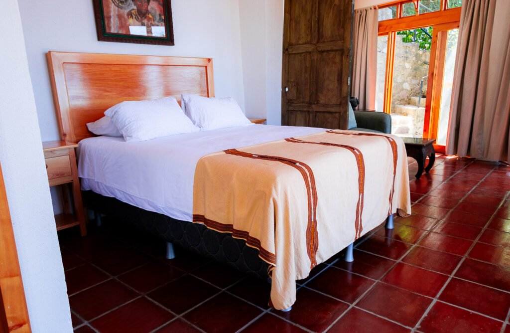 Villa Gio bedroom with queen bed and terracotta tile floor.