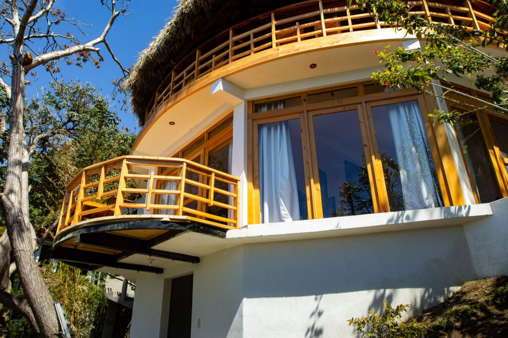 Villa Gio's unique architecture featuring a round balcony and thatched roof.