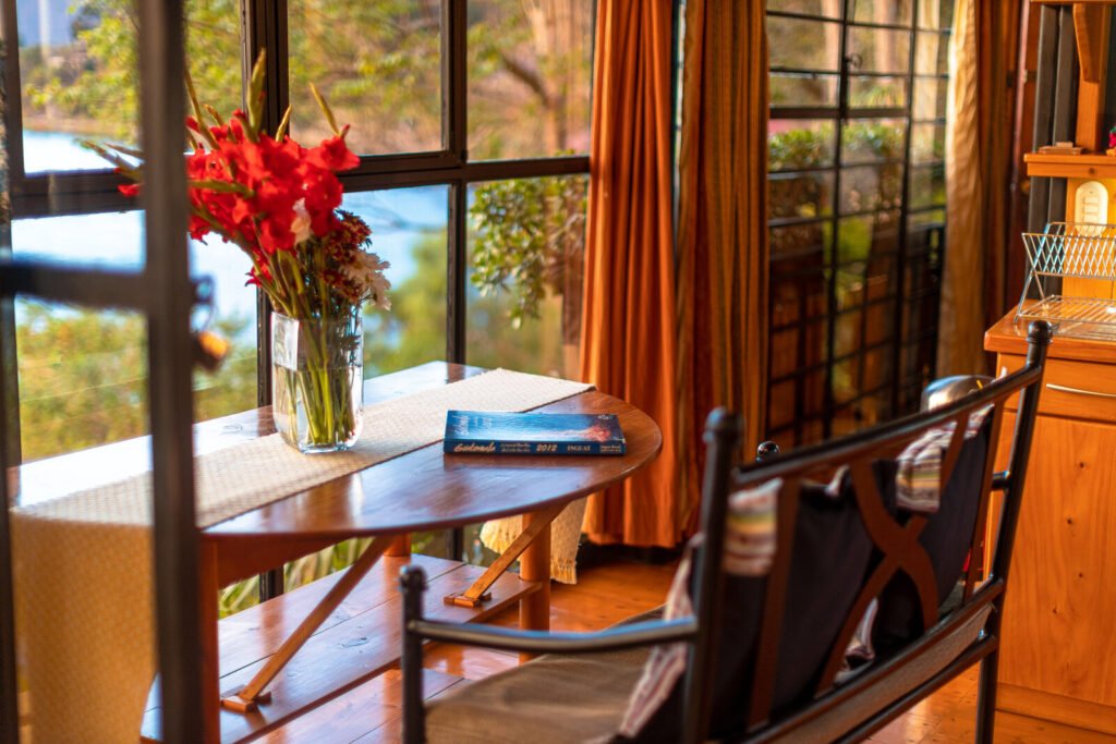 Villa Jade dining table with flowers and book by window.