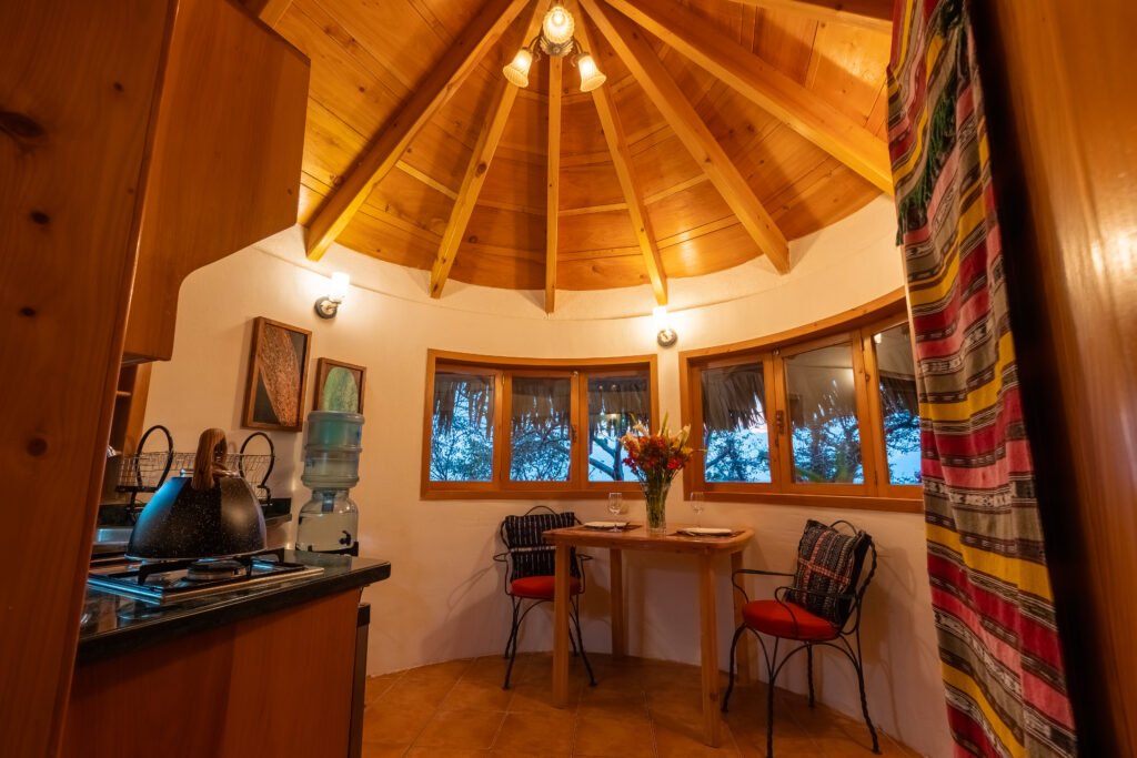 Villa Loft interior: cozy dining nook with a round wooden ceiling and kitchen area.