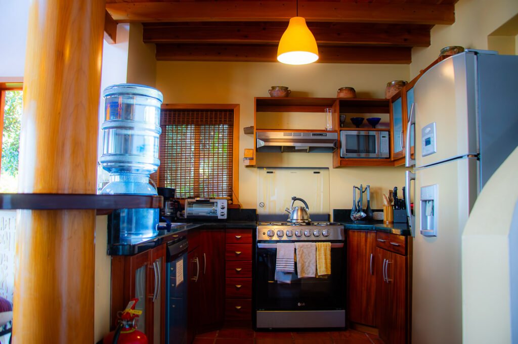 Villa Mirador kitchen with wood cabinets, stainless steel appliances, and a water cooler.