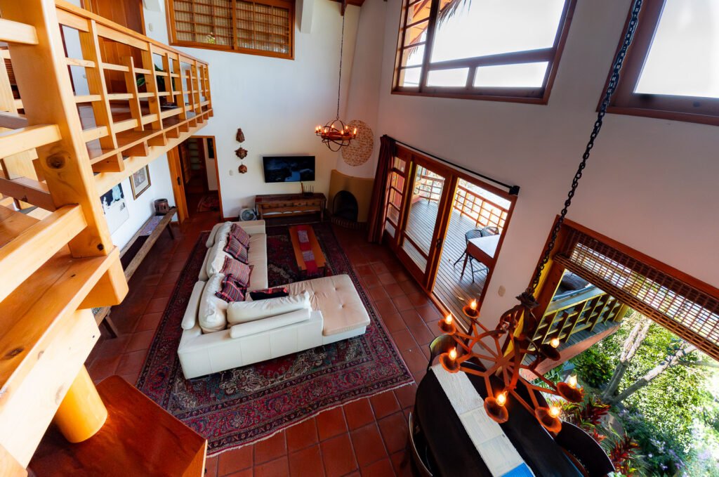 Villa Mirador's bright living room with high ceilings, a balcony, and a large rug.
