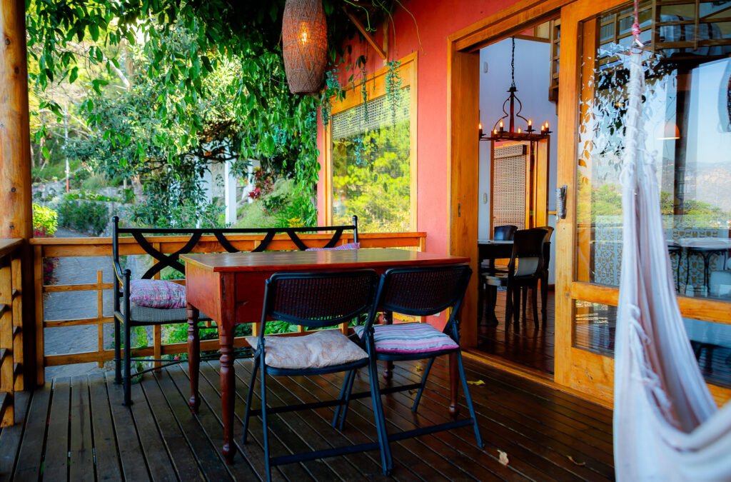 Villa Mirador: Outdoor dining area with table, chairs, and lush greenery, inviting ambiance.
