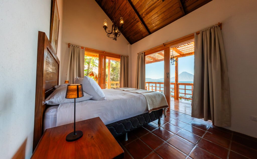 Villa Shakti bedroom with lake view. Cozy room with wooden ceiling and terracotta tile floor.