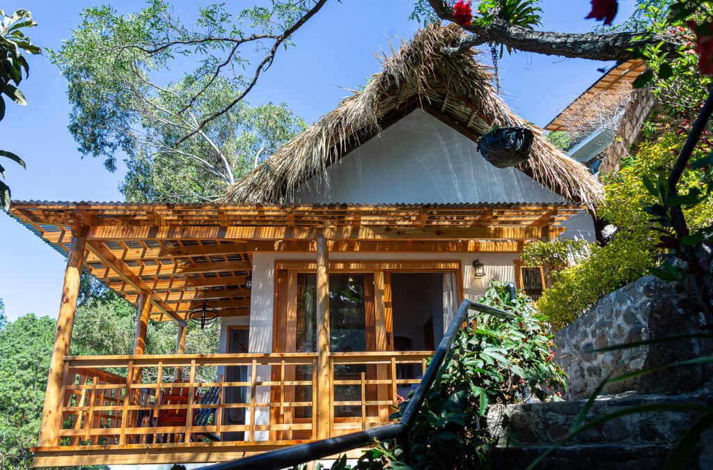 Villa Shakti cabin with thatched roof and wooden deck.