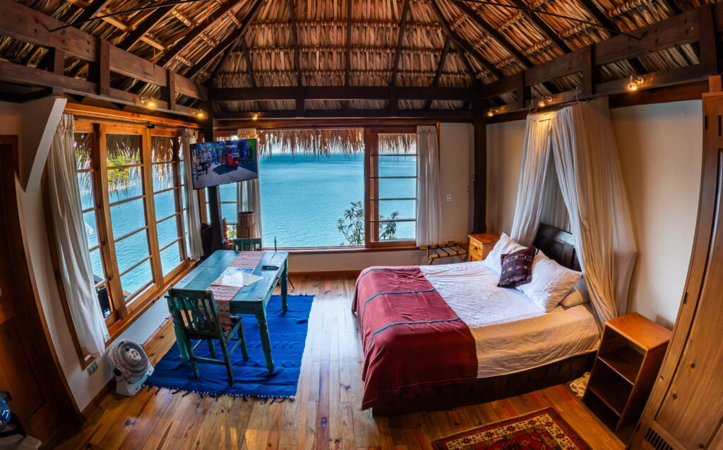 Villa Soluna bedroom with ocean view, thatched roof, and cozy decor.