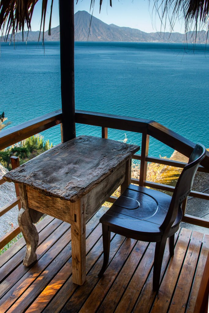 Wooden table and chair on a balcony overlooking Lake Atitlán, Guatemala.