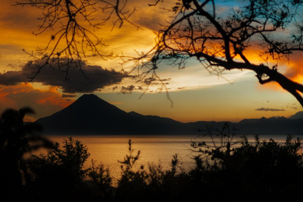 Sunset over Lake Atitlan with volcano and silhouetted trees